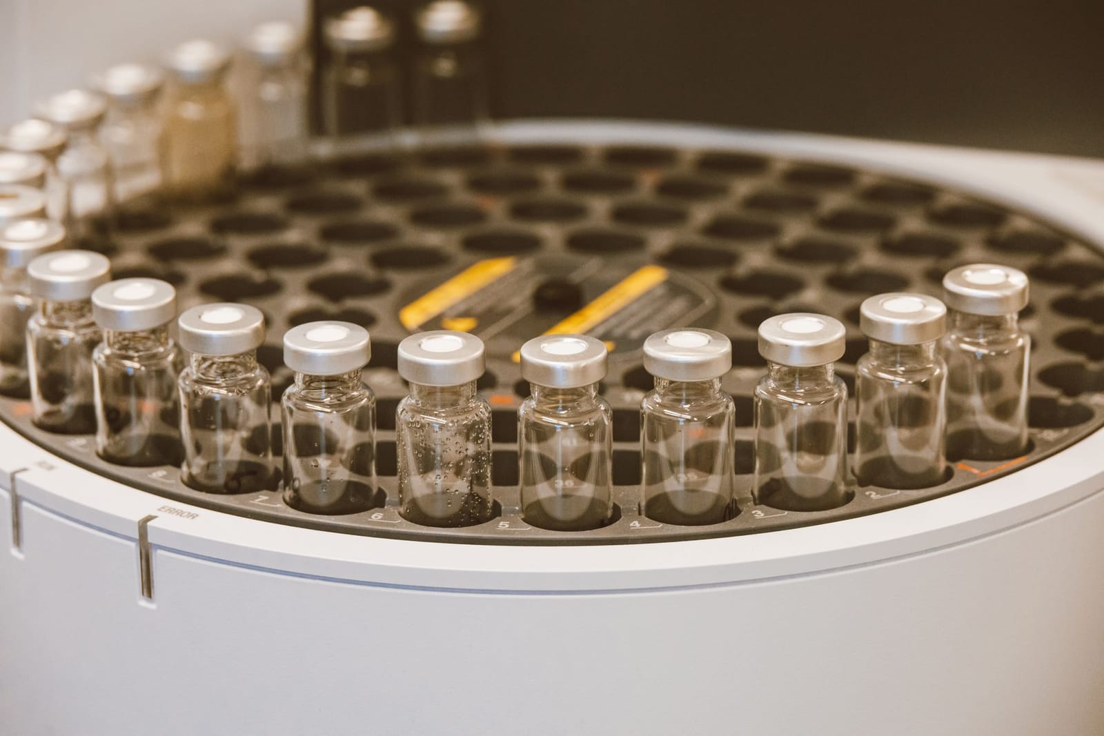 Rows of capped glass vials in a laboratory tray
