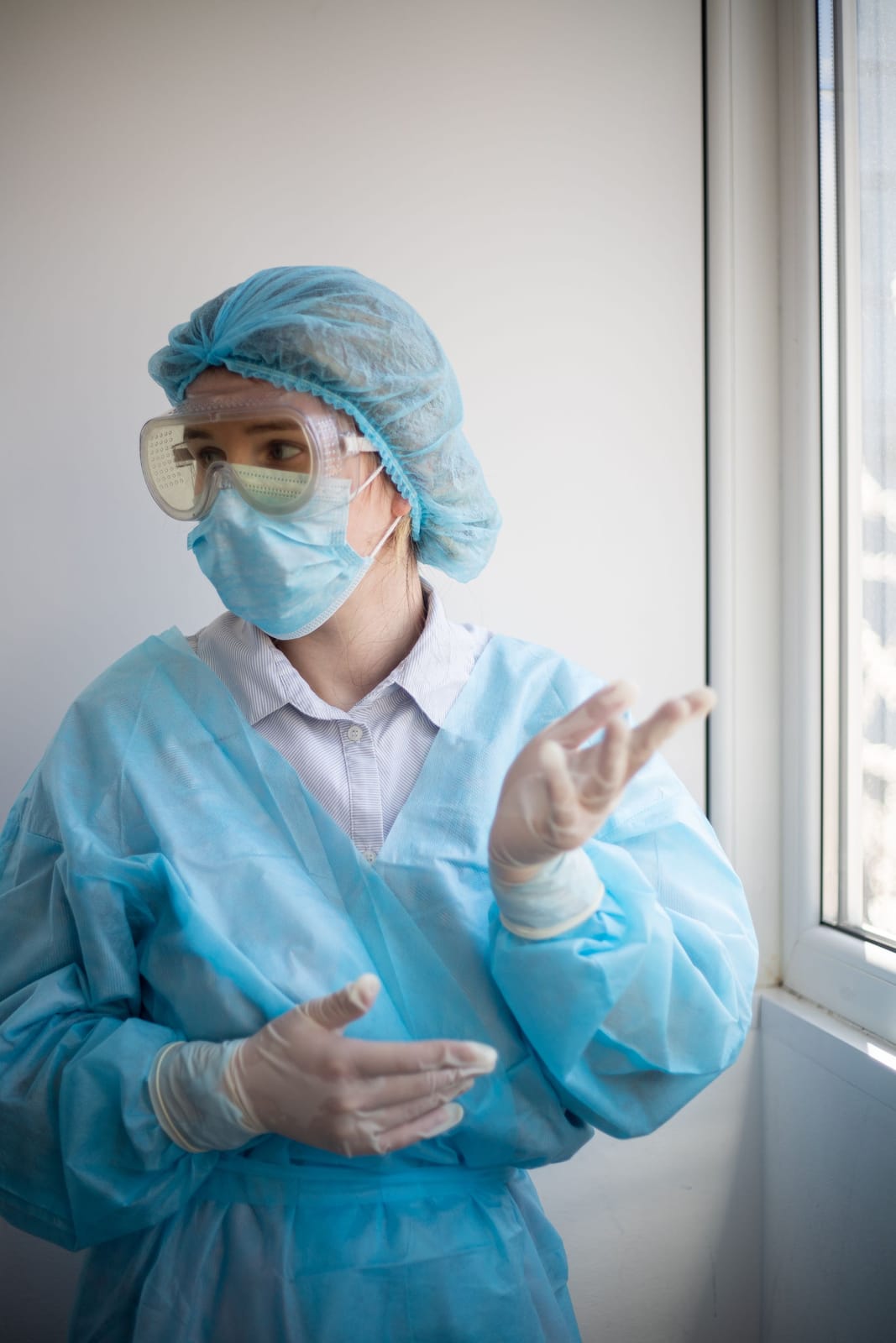 Nurse wearing a disposable isolation gown, cap, mask and gloves
